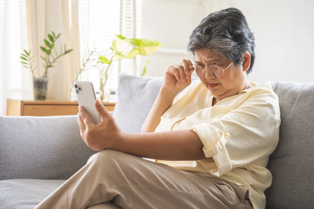 Woman experiencing difficulty reading due to blurred vision from cataracts